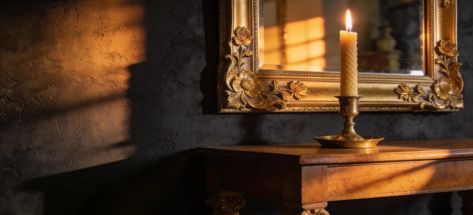Grand miroir doré ancien reflétant la flamme d'une bougie dans un intérieur sombre.