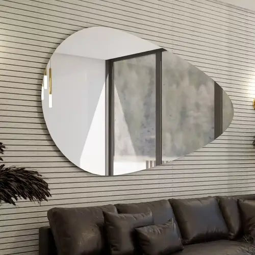 Gros plan sur un miroir mural design en forme de goutte de 120x70 cm, accroché au mur dans un salon moderne et élégant