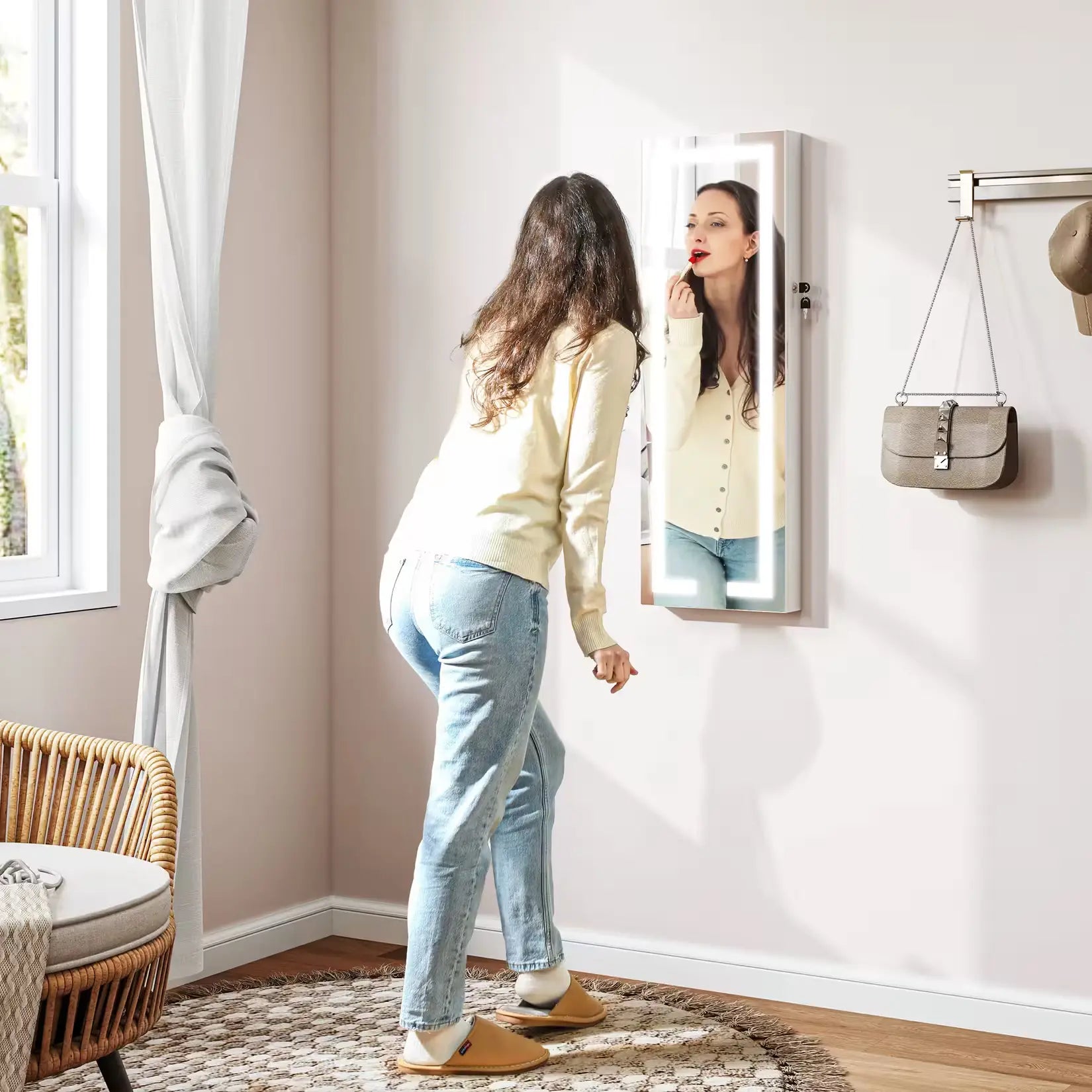 Armoire à bijoux avec miroir LED en utilisation, rangement mural pratique pour chambre ou entrée.