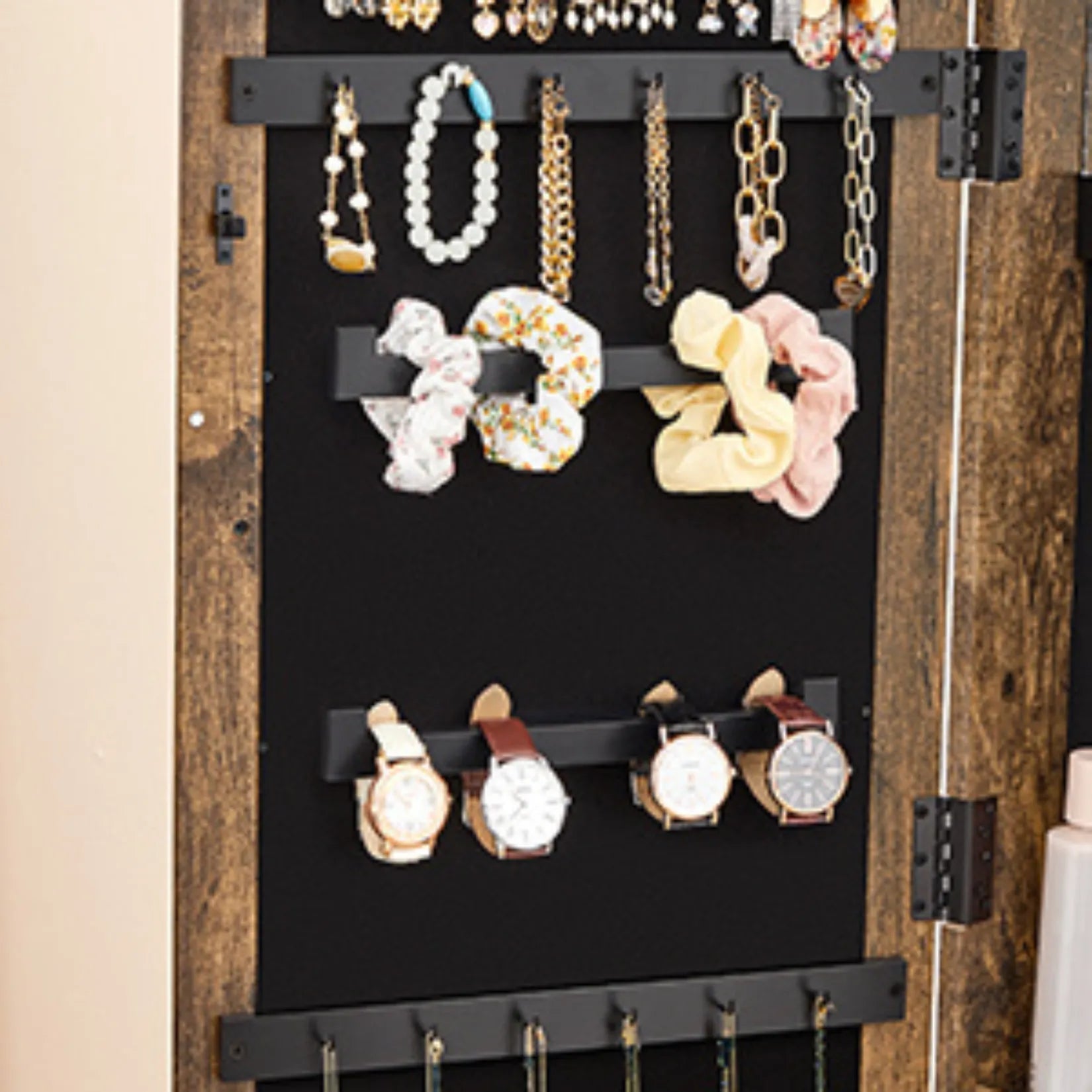 Zone de rangement pour montres, bracelets et élastiques dans une armoire à bijoux sur pied en bois.