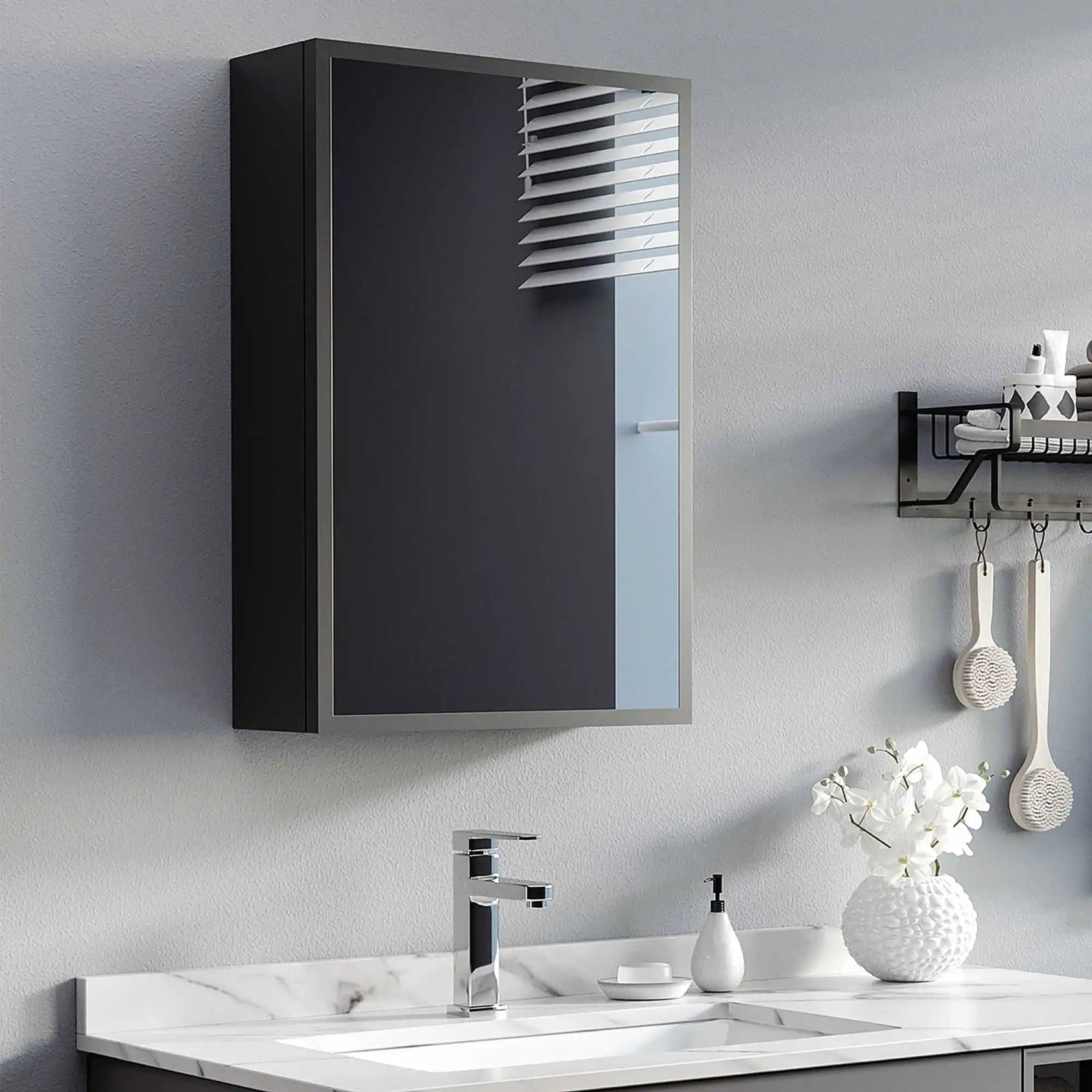 Armoire de toilette miroir noire installée au mur dans une salle de bain contemporaine.
