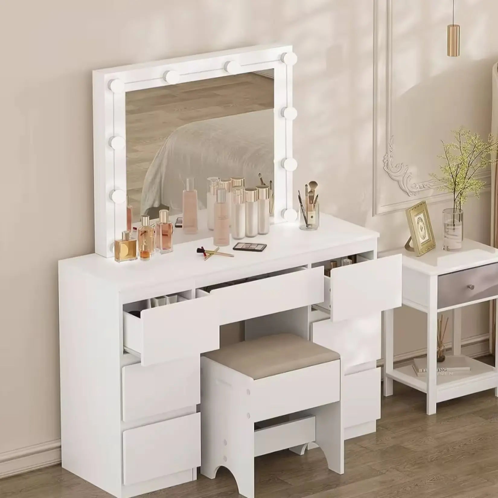 Coiffeuse blanche avec grand miroir LED, tiroirs ouverts et petit tabouret dans une chambre élégante.