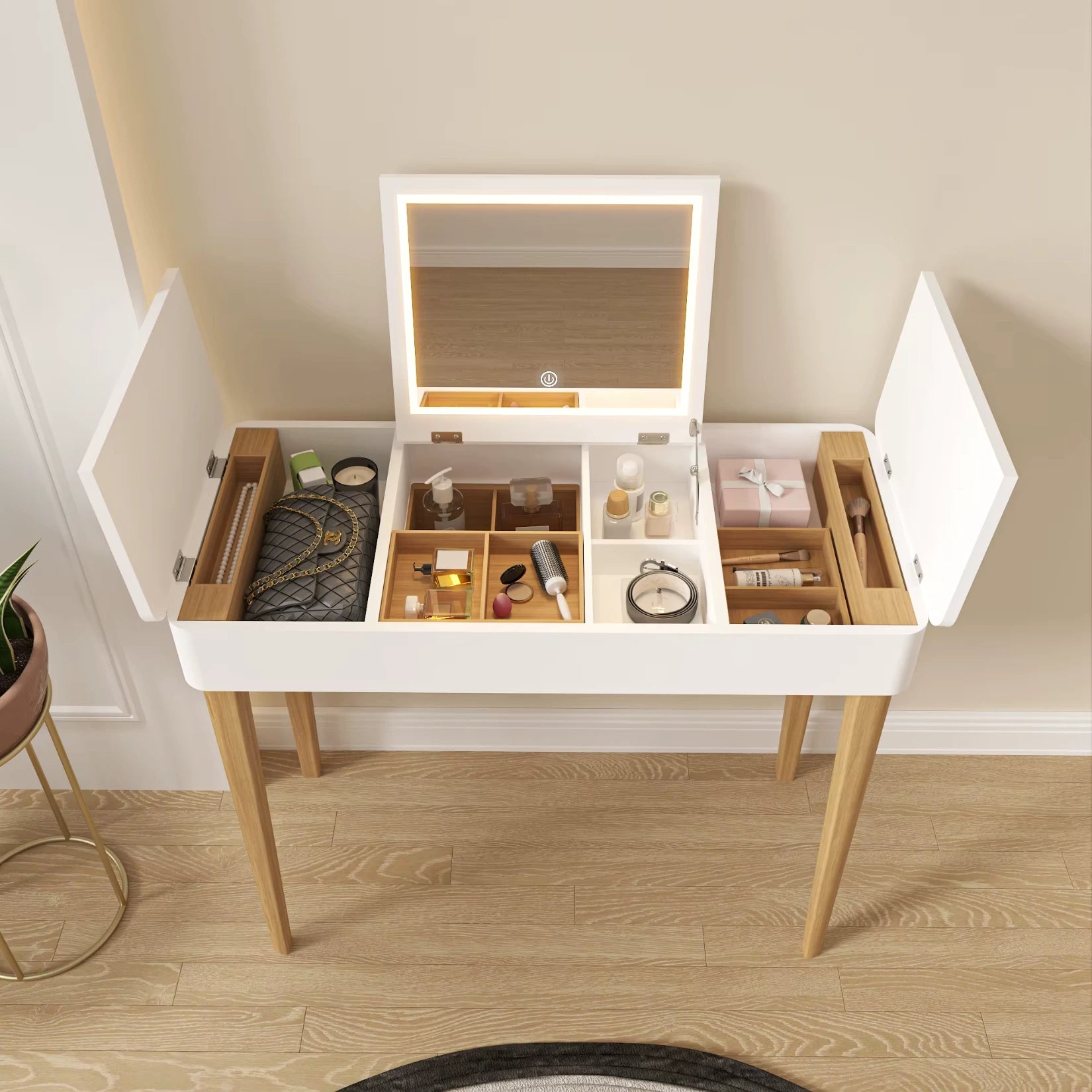 Vue haute de la coiffeuse avec miroir rabattable et rangements remplis.