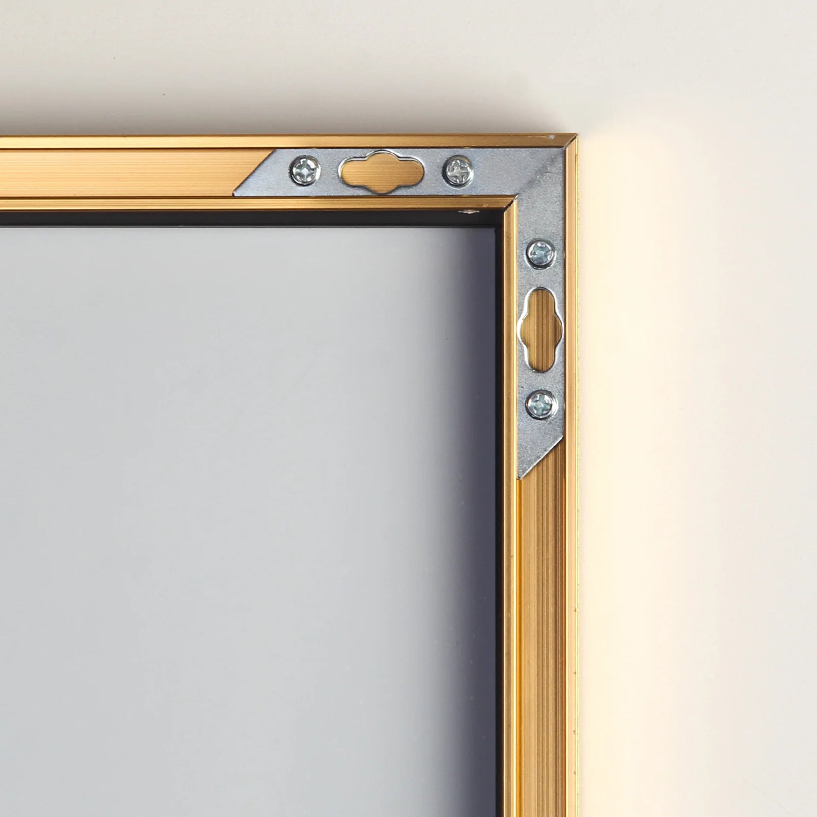 Zoom sur le cadre métallique doré du miroir 180x80 cm avec système mural.