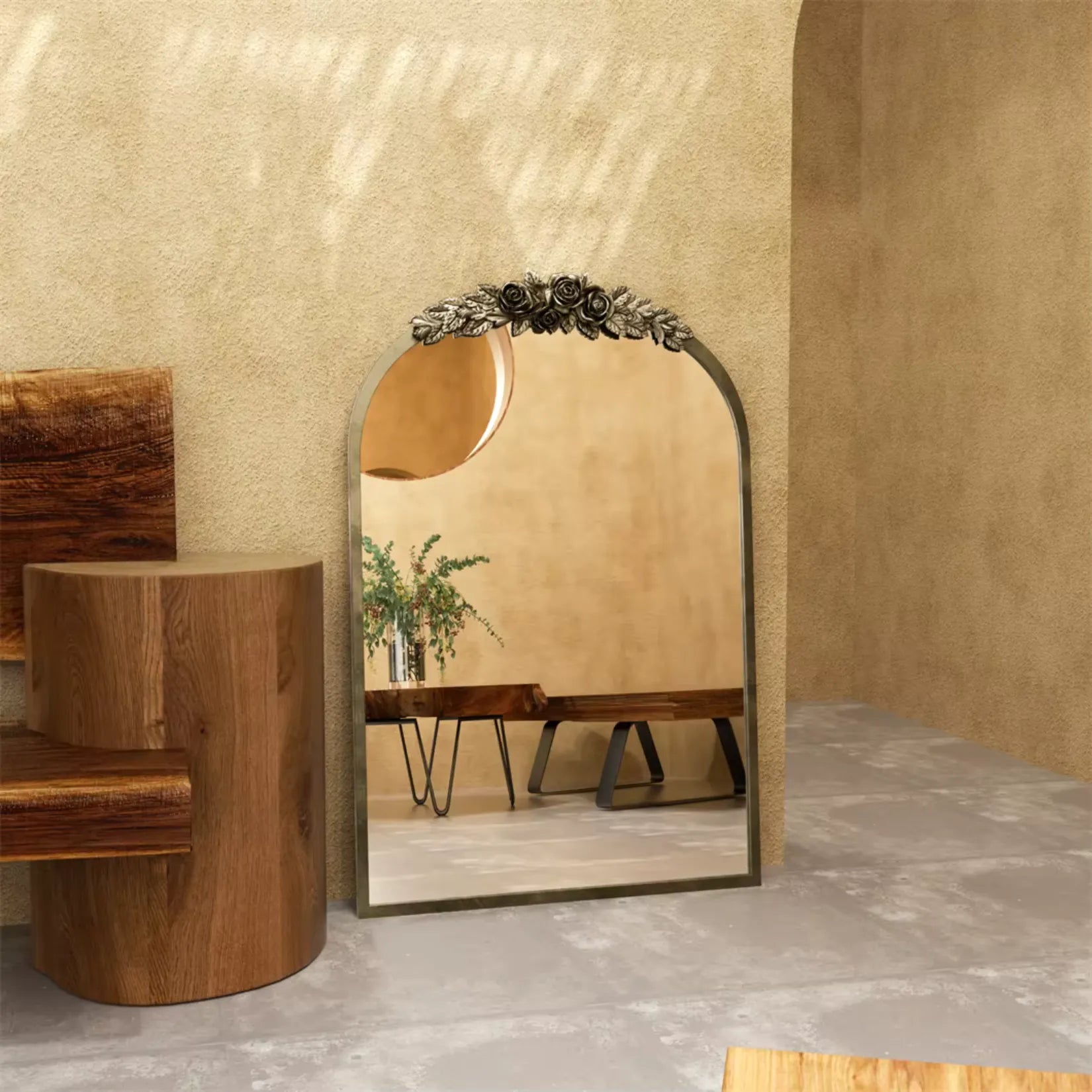 Miroir baroque doré posé au sol contre un mur texturé beige, décor minimaliste mais plein de charme et de noblesse.