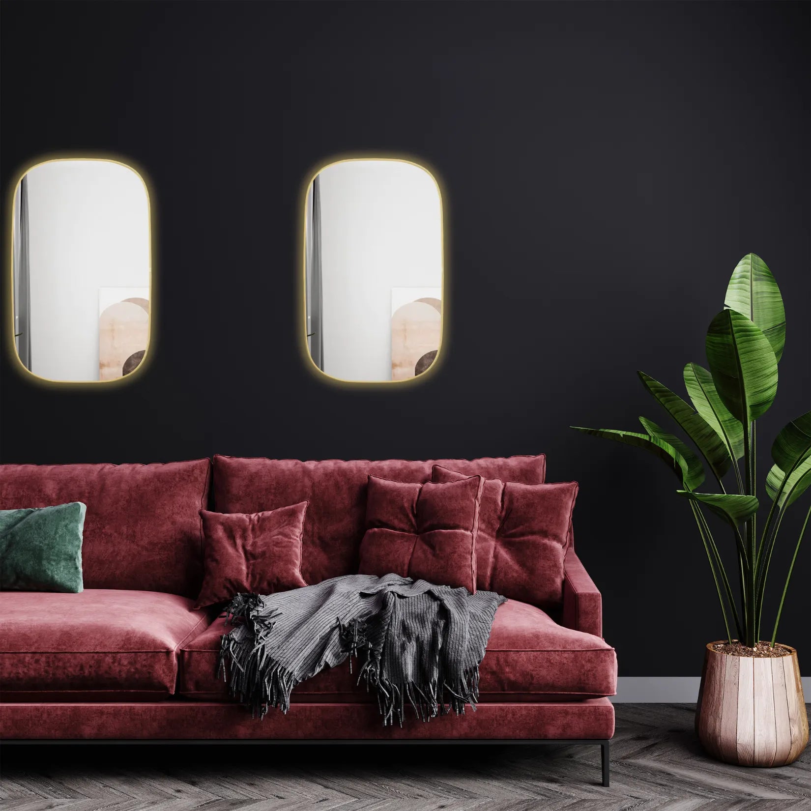 Duo de miroirs contour doré dans une pièce avec mur noir et canapé en velours.