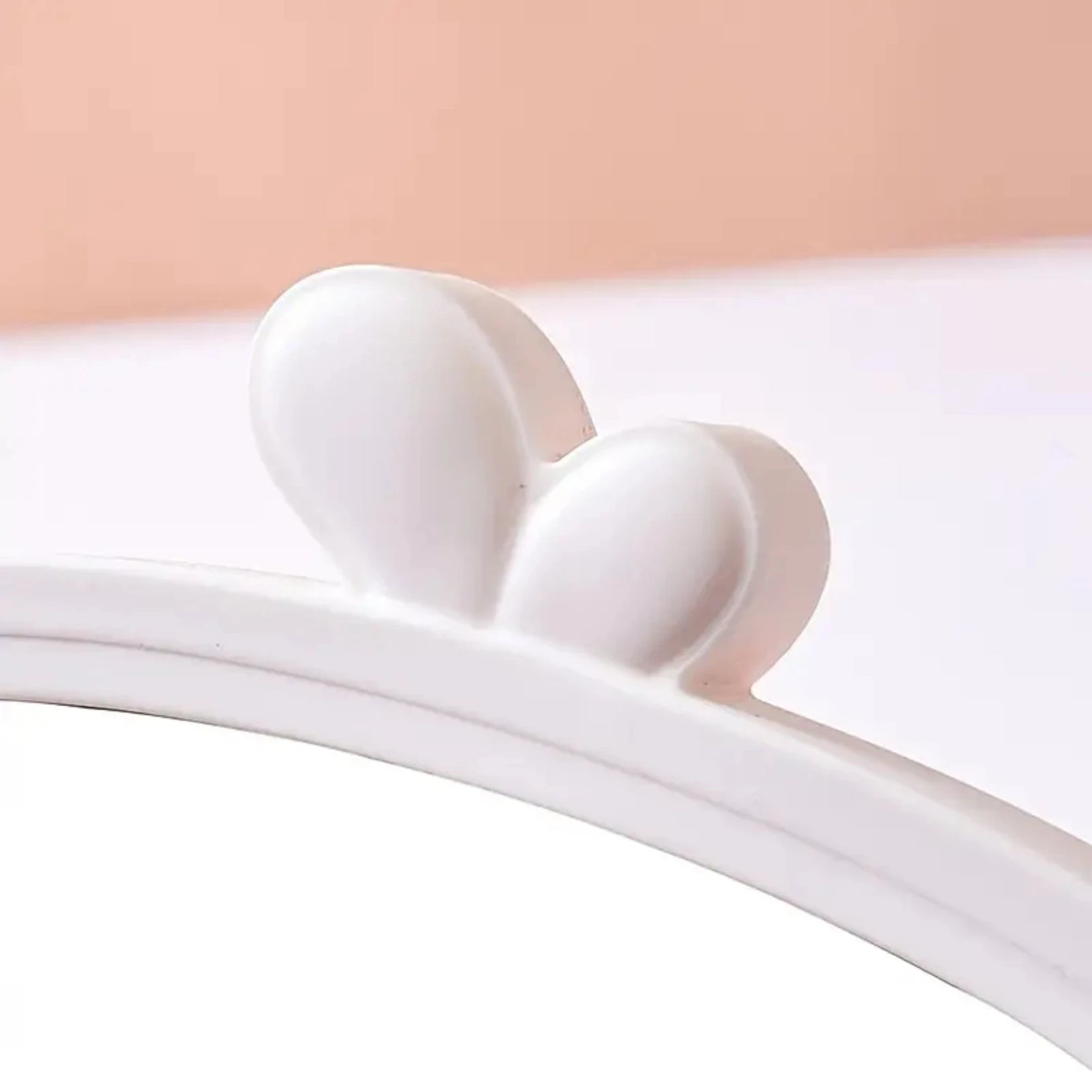 Détail de l’ornement supérieur du miroir de table, finition lisse en plastique.