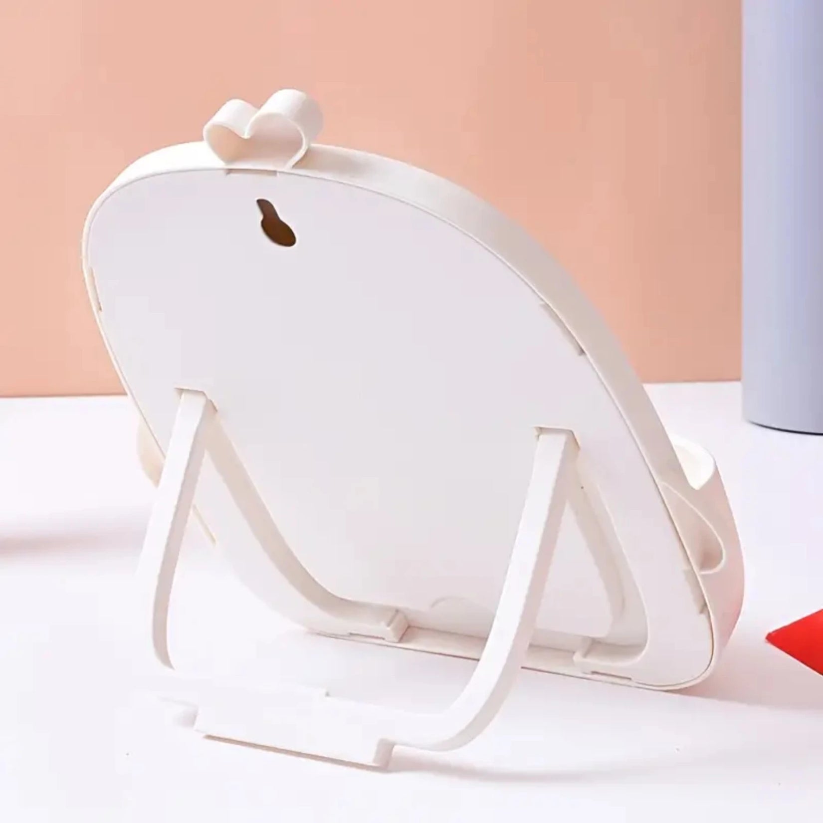 Dos du miroir de table avec béquille de pose et trou de suspension murale.