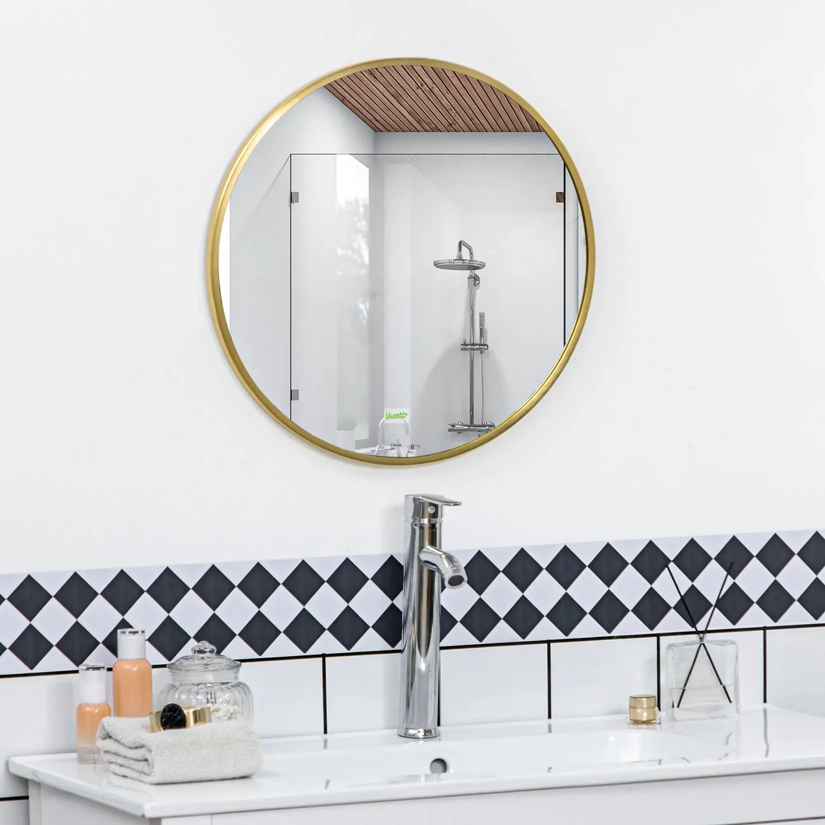 Miroir doré salle de bain rond 50 cm monté au-dessus d'une vasque, carrelage noir et blanc.