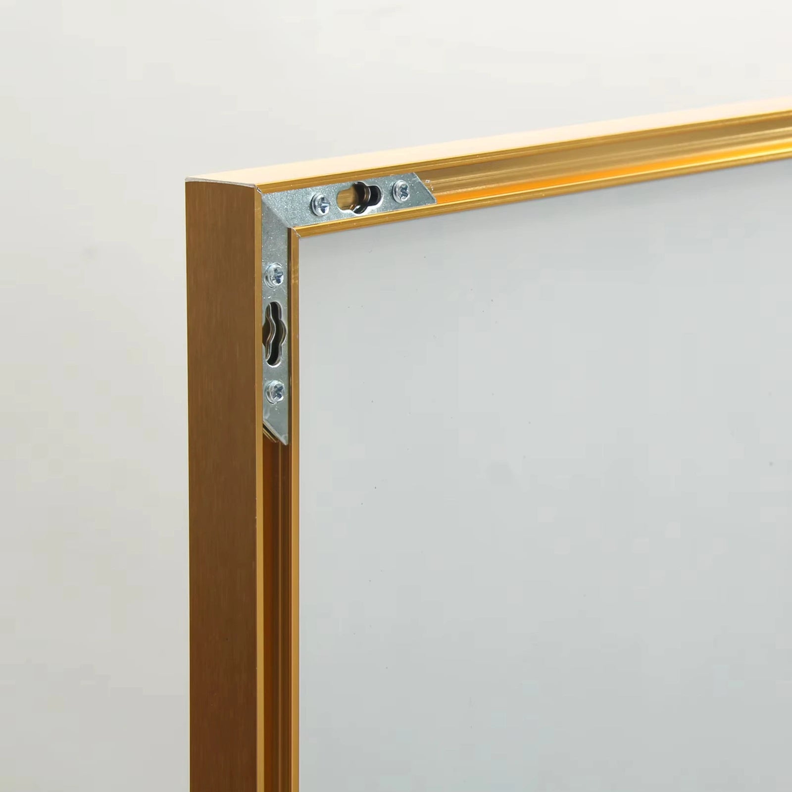 Cadre en aluminium doré du miroir sur pied, aspect brillant et robuste.