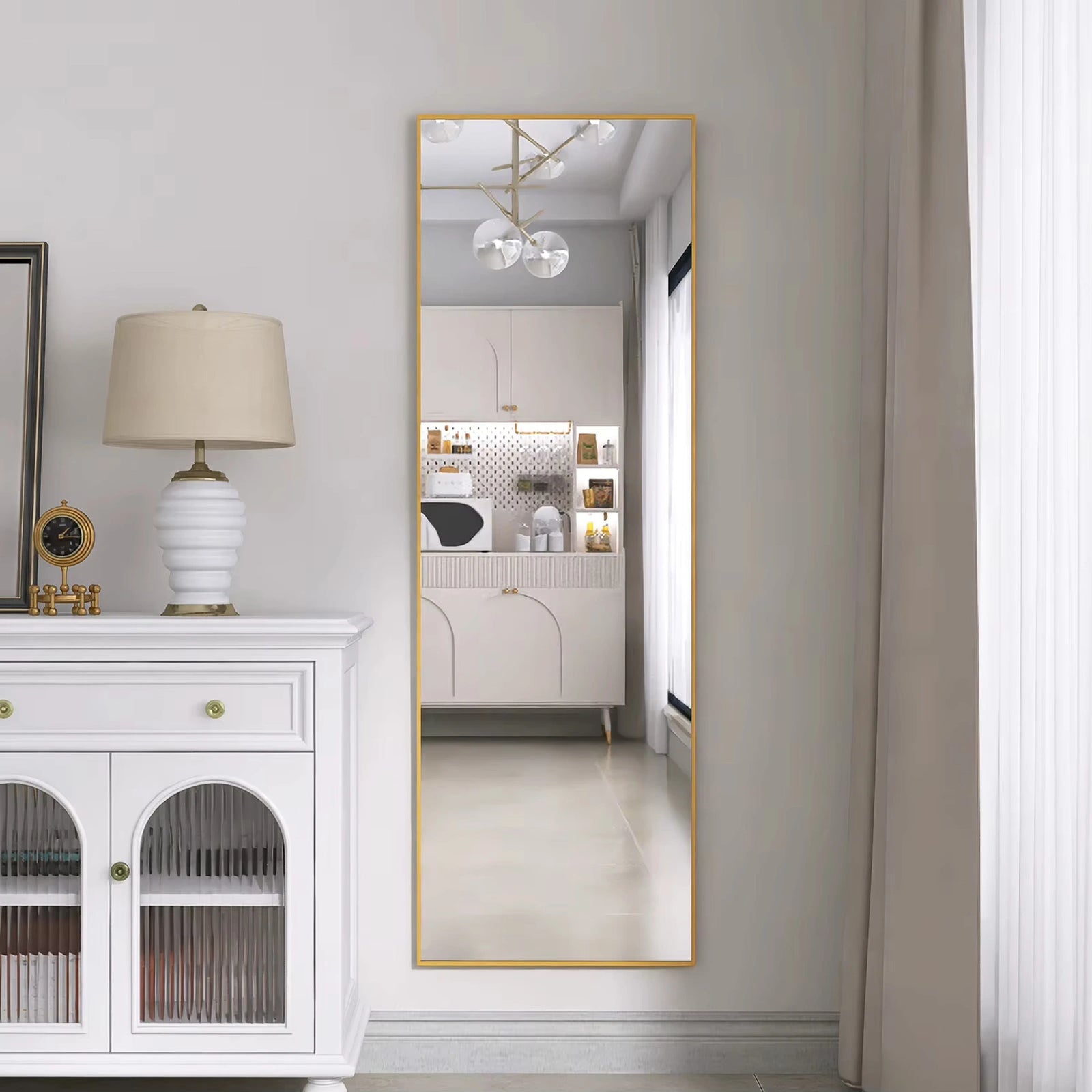 Miroir doré sur pied fixé sur un mur blanc, parfait pour les intérieurs lumineux.