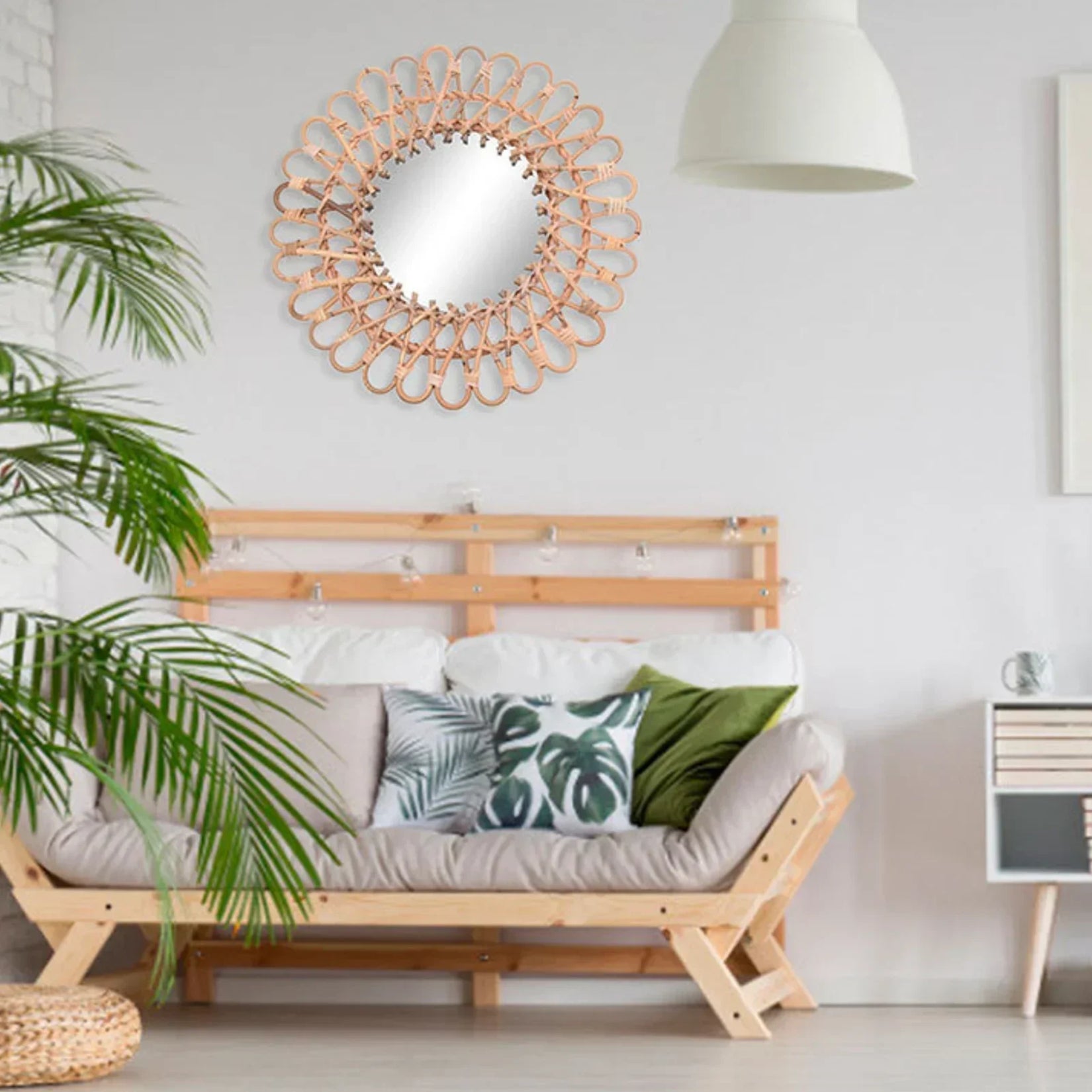 Miroir fleur rotin accroché au-dessus d’un canapé dans un salon moderne et lumineux.