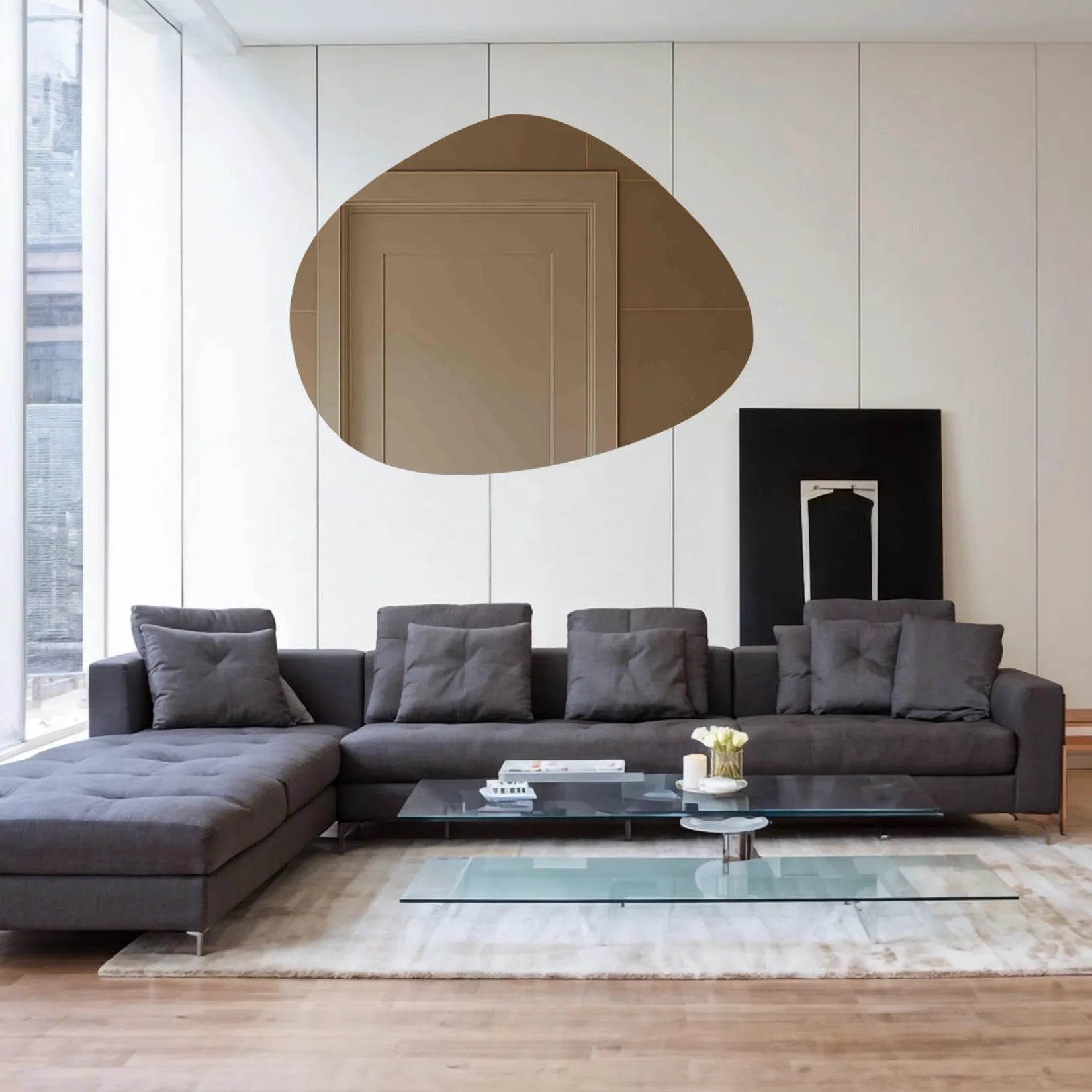 Miroir Galet 150x115 cm dans un salon moderne avec canapé gris.