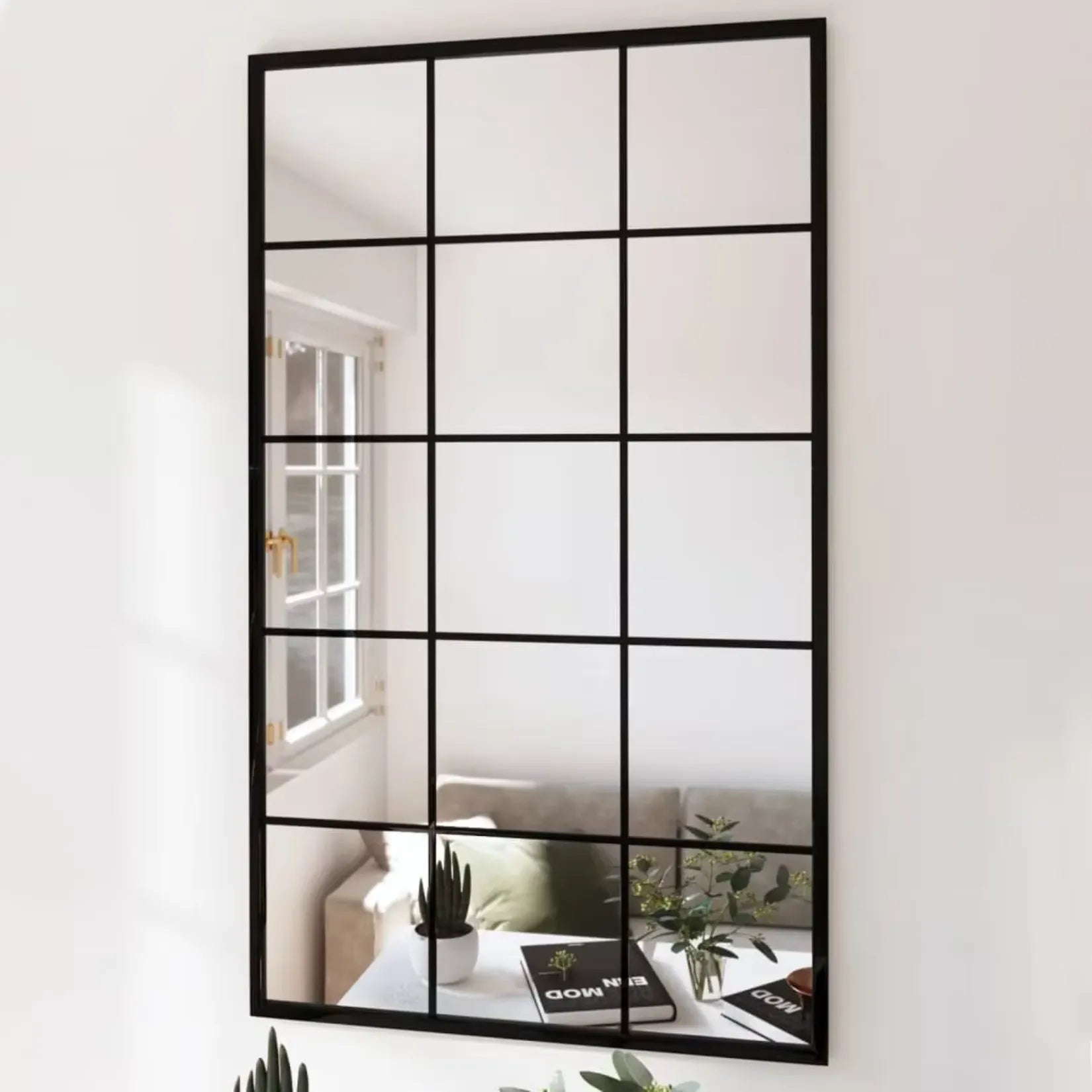 Miroir industriel noir dans un salon lumineux avec plantes décoratives.