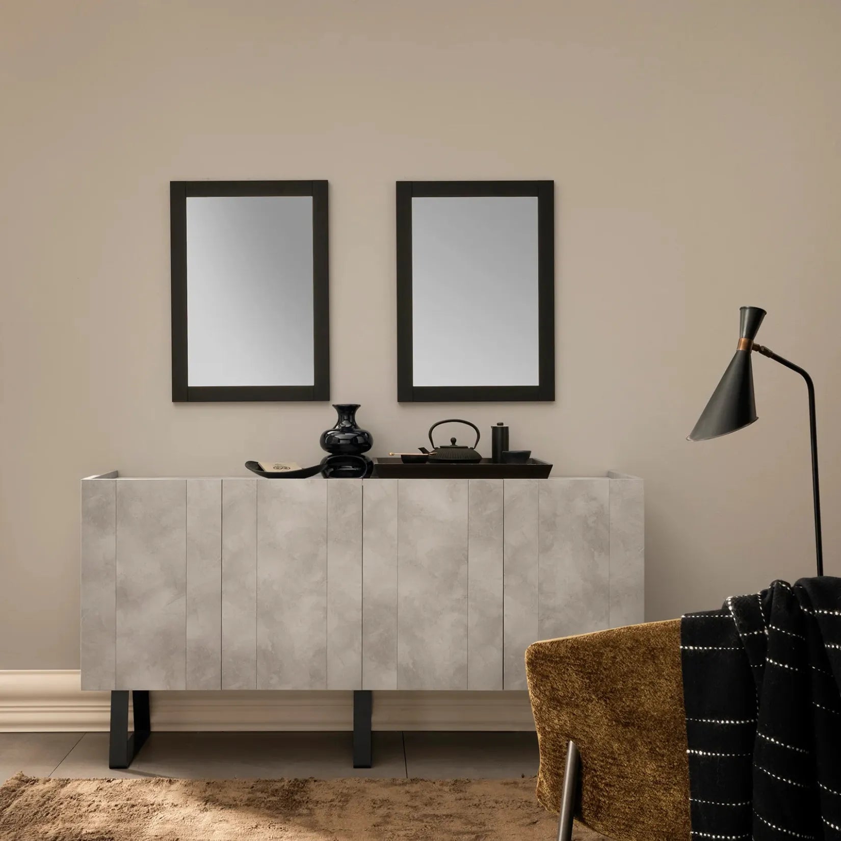 Deux miroirs minimalistes noirs au-dessus d’un meuble console beige dans un intérieur contemporain.