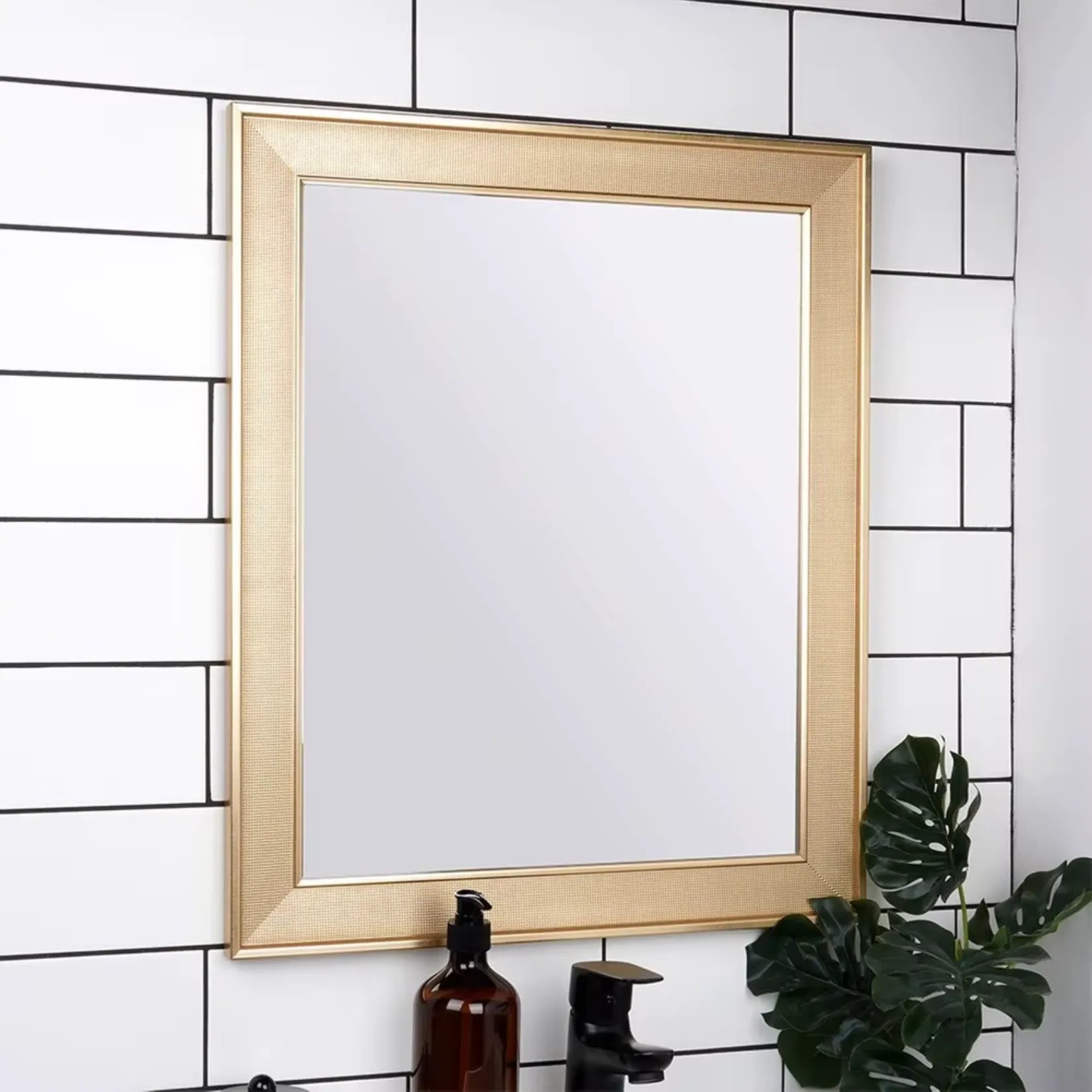 Miroir mural doré en position verticale dans salle de bain contemporaine.