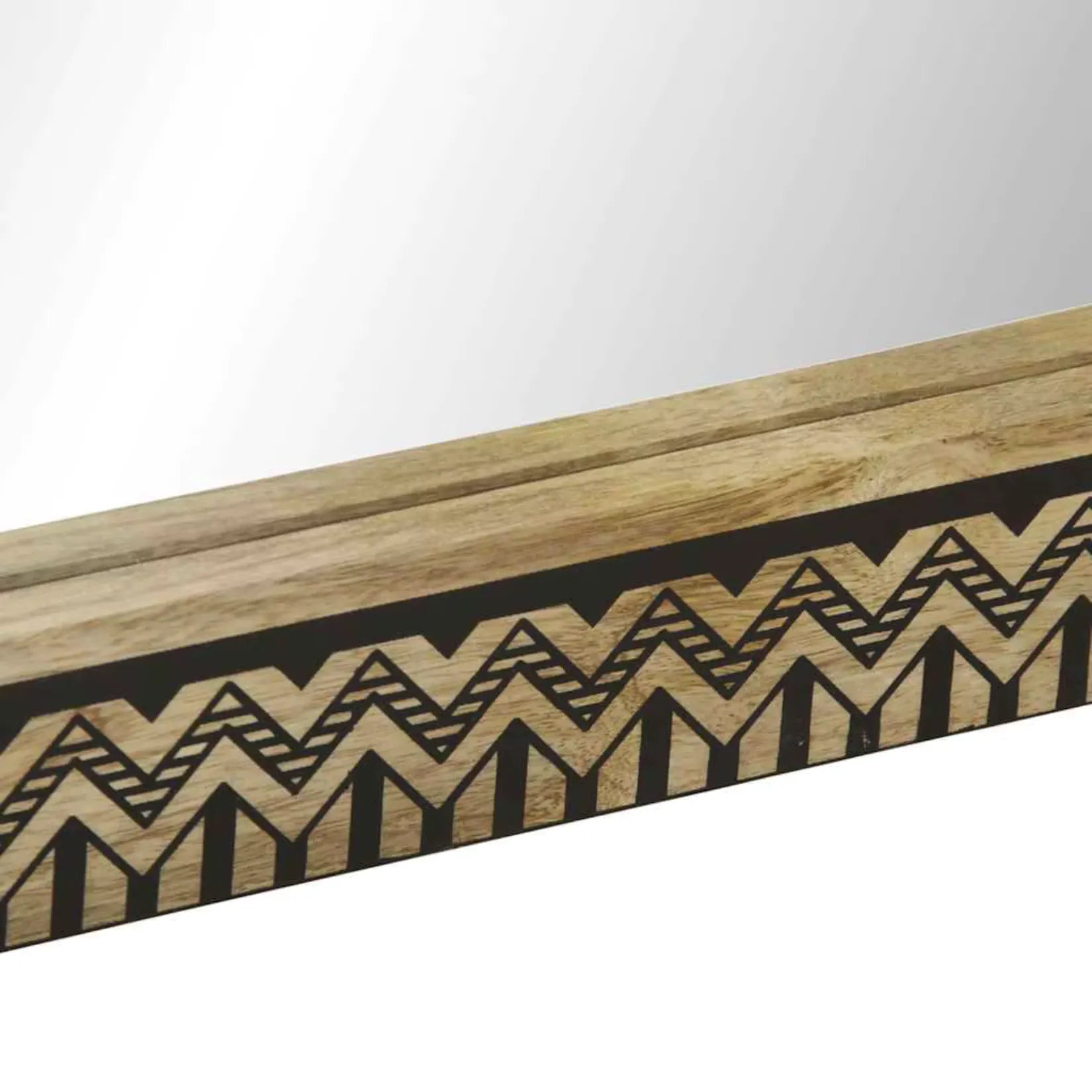 Zoom sur le cadre sculpté du miroir mural rectangulaire en bois de manguier.