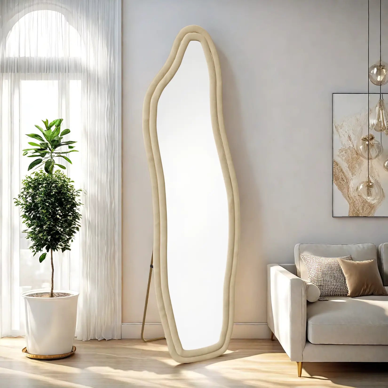 Miroir organique beige pleine longueur, appuyé contre un mur près d’un canapé.