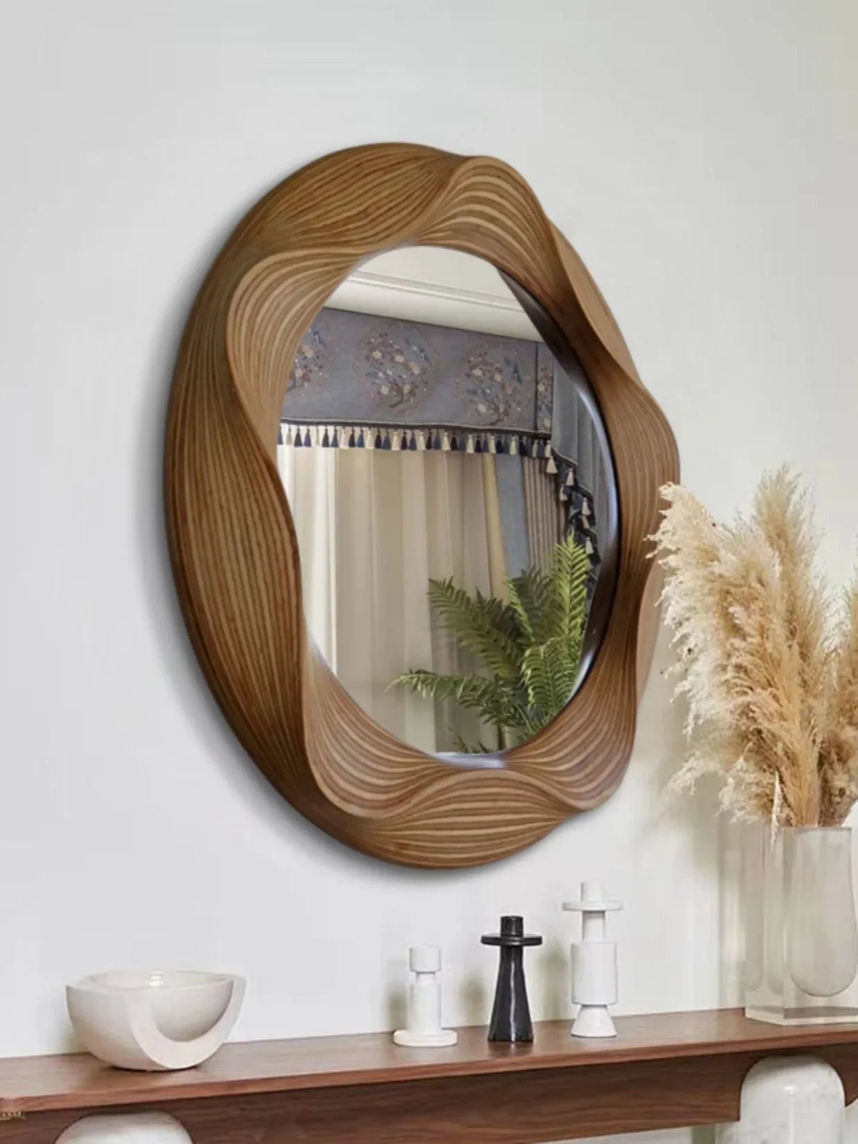 Miroir rond bois sculpté cadre ondulé dans une chambre.