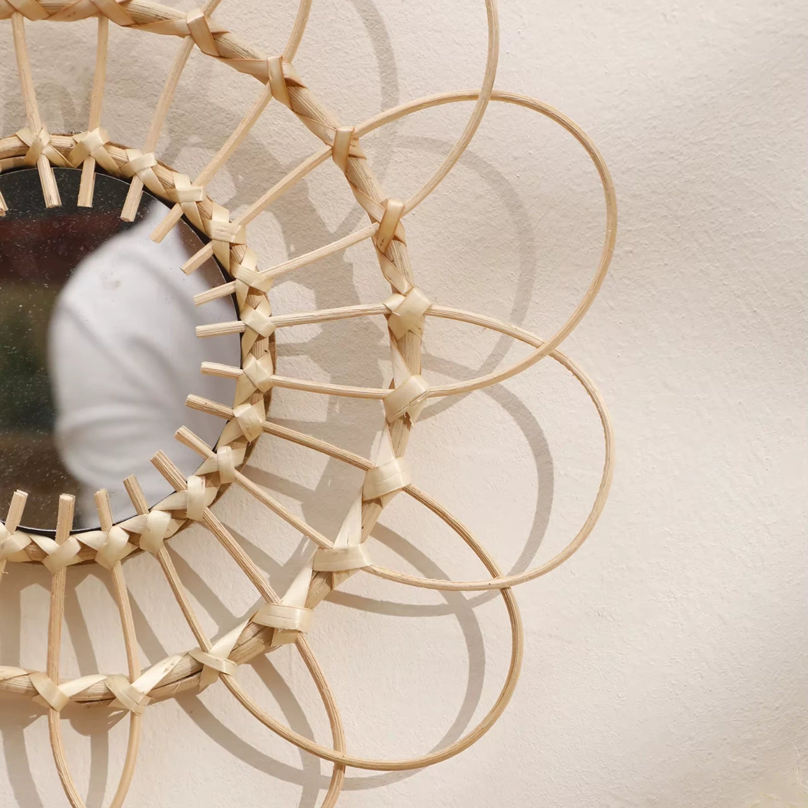 Gros plan sur le tressage artisanal du miroir rotin soleil, mettant en valeur son design unique.
