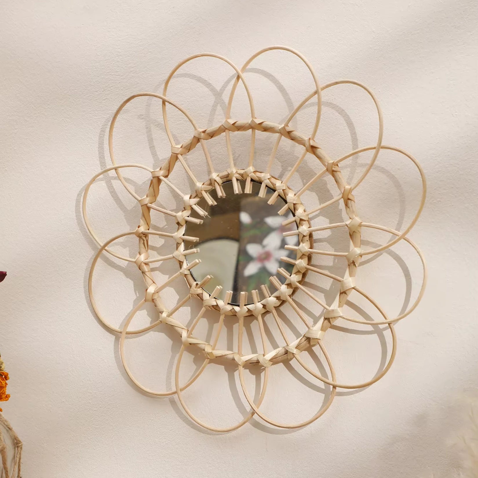 Miroir rotin soleil dans une chambre cosy, ajoutant une touche naturelle et chaleureuse.