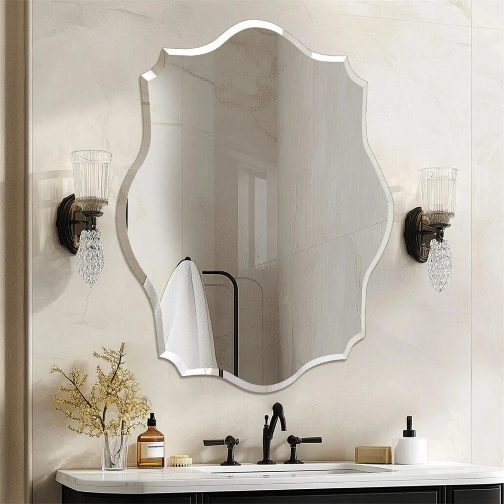 Miroir salle de bain design asymétrique fixé sur mur beige avec appliques cristal.