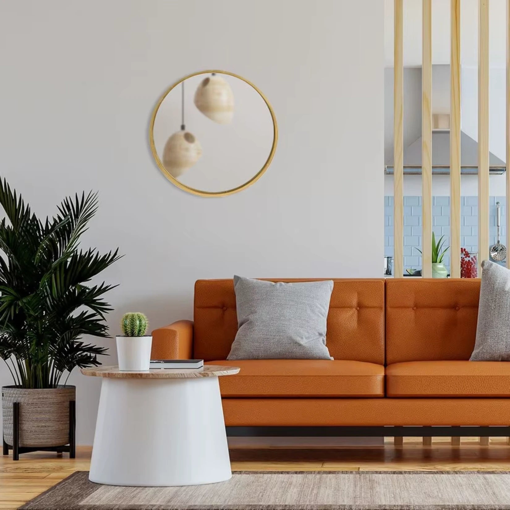 Miroir scandinave rond en bois doré au-dessus d’un canapé orange dans un salon lumineux.