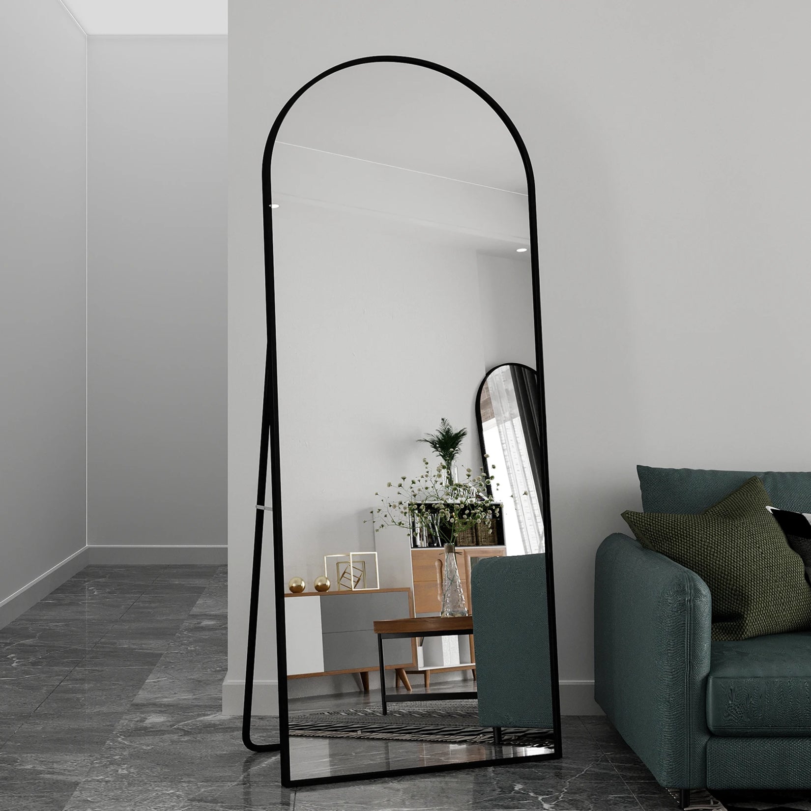 Miroir noir sur pied dans un salon au style industriel chic avec fauteuil vert.