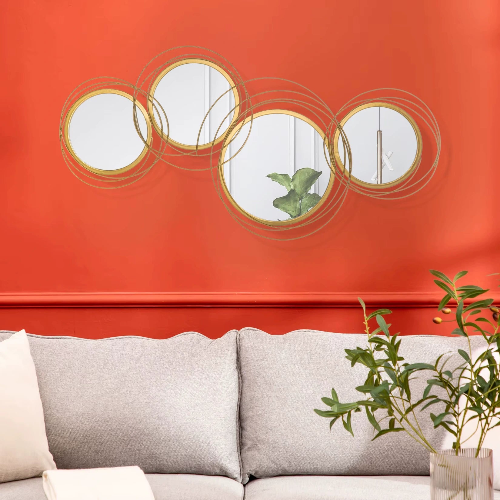 Mise en scène murale des miroirs ronds dorés entrelacés dans un salon lumineux et moderne.