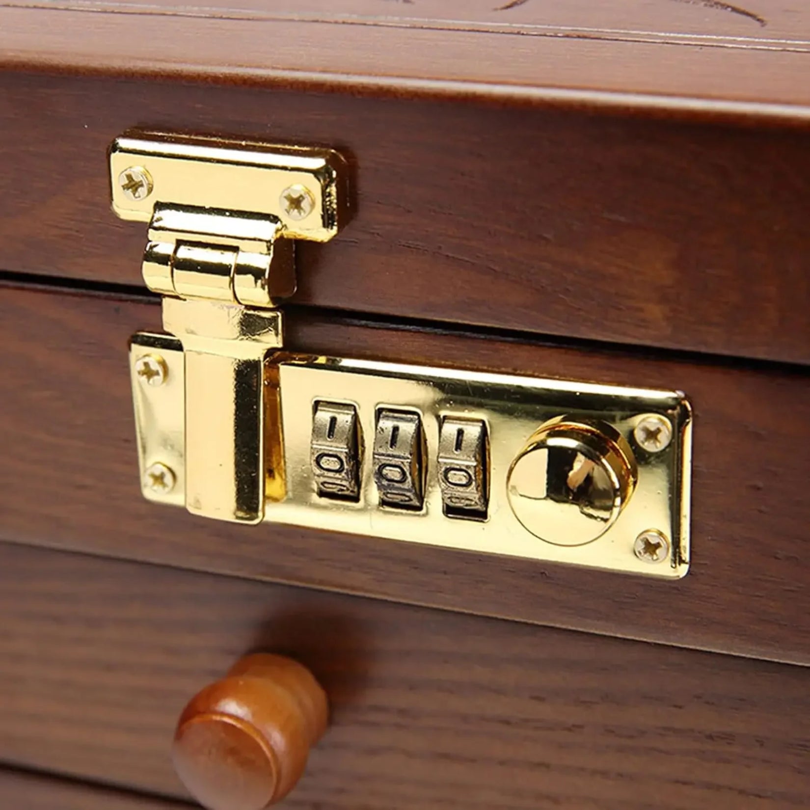 Détail du verrou à combinaison doré de l’armoire à bijoux miroir.