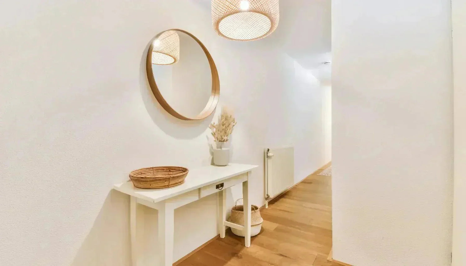 Miroir au cadre rond placé dans une entrée étroite pour agrandir l'espace par  reflet.