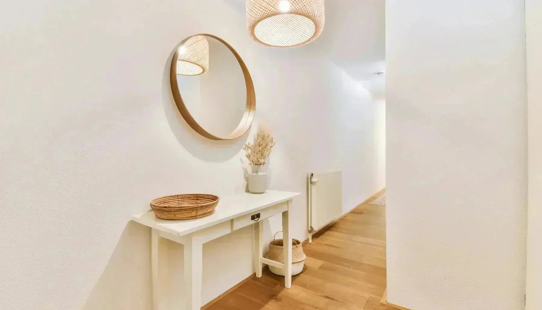 Miroir au cadre rond placé dans une entrée étroite pour agrandir l'espace par  reflet.