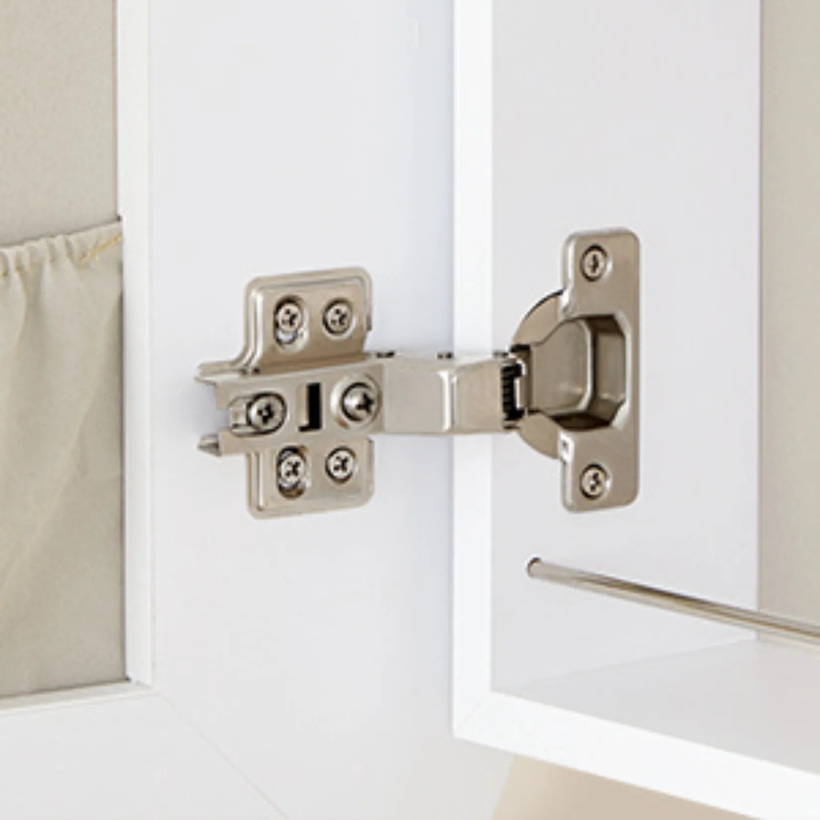 Charnière en métal robuste d’une armoire à bijoux murale blanche.