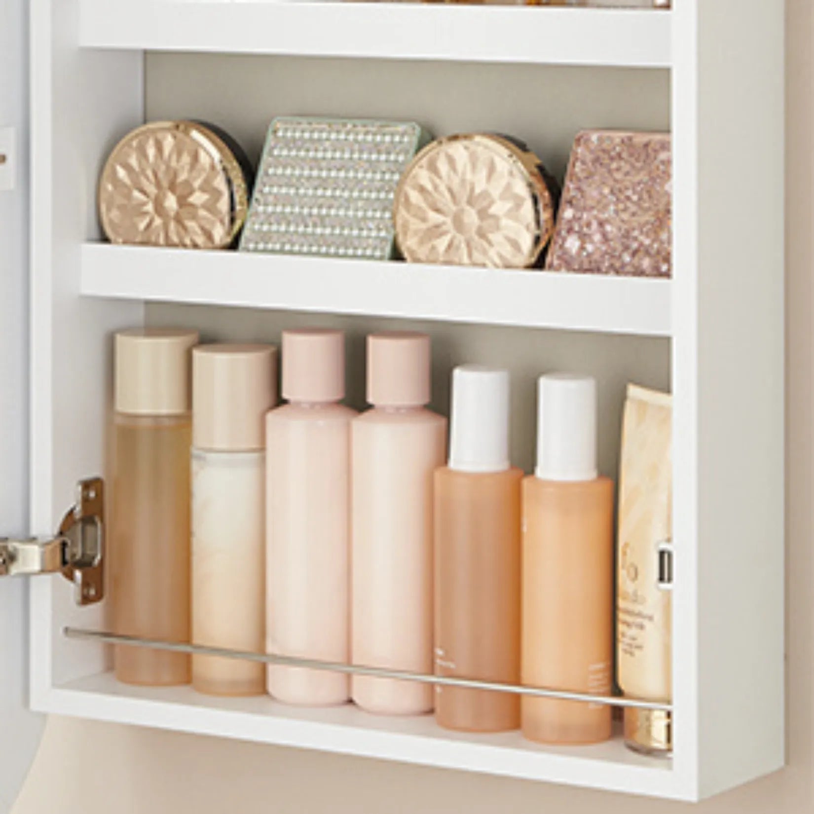 Armoire à bijoux murale avec flacons de parfums et maquillage bien rangés.