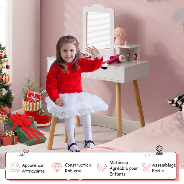 Petite fille assise devant sa coiffeuse enfant avec vrai miroir en train de jouer.