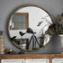 Grand miroir rond bois mural installé au-dessus d’un meuble vintage.
