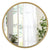 Grand Miroir Rond Doré placé au-dessus d'une console d'entrée au style épuré.