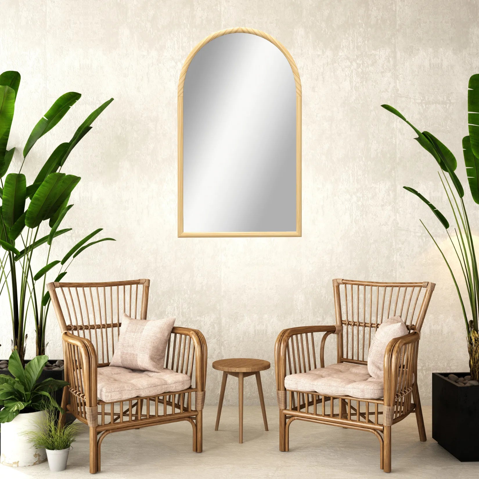 Miroir arche bois accroché dans un salon avec fauteuils en rotin et plantes vertes.