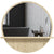 Miroir rond avec étagère dans une salle de bain design épuré.