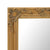 Détail sculpté du cadre doré du miroir baroque, motifs floraux raffinés et reliefs majestueux.
