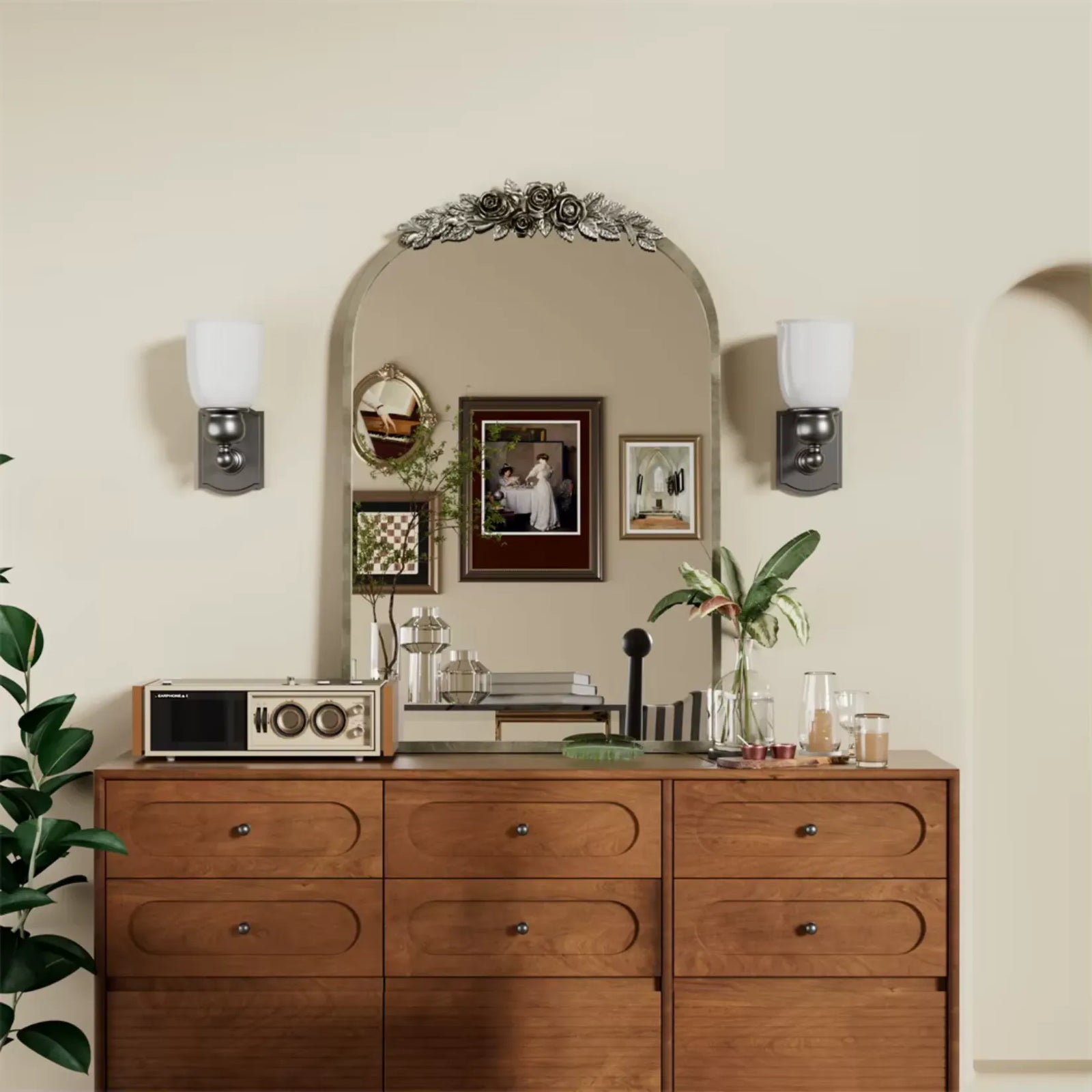 Décoration rétro avec un miroir baroque doré au-dessus d’un meuble en bois orné de touches végétales et d’objets vintage.