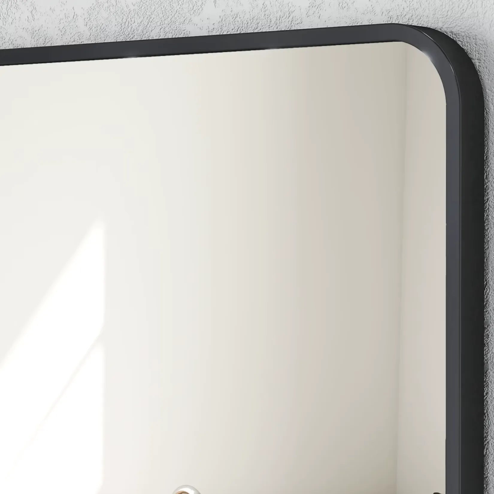 Zoom sur le cadre noir arrondi du miroir rectangulaire au design épuré.