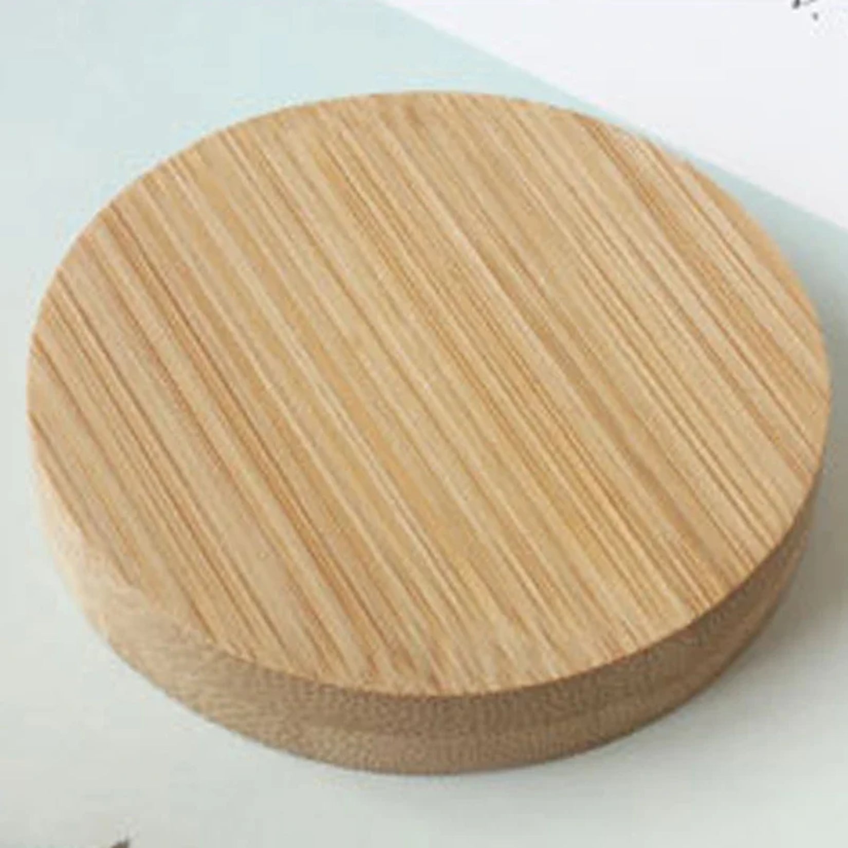 Vue rapprochée d’un miroir de poche bois fermé sur surface claire.