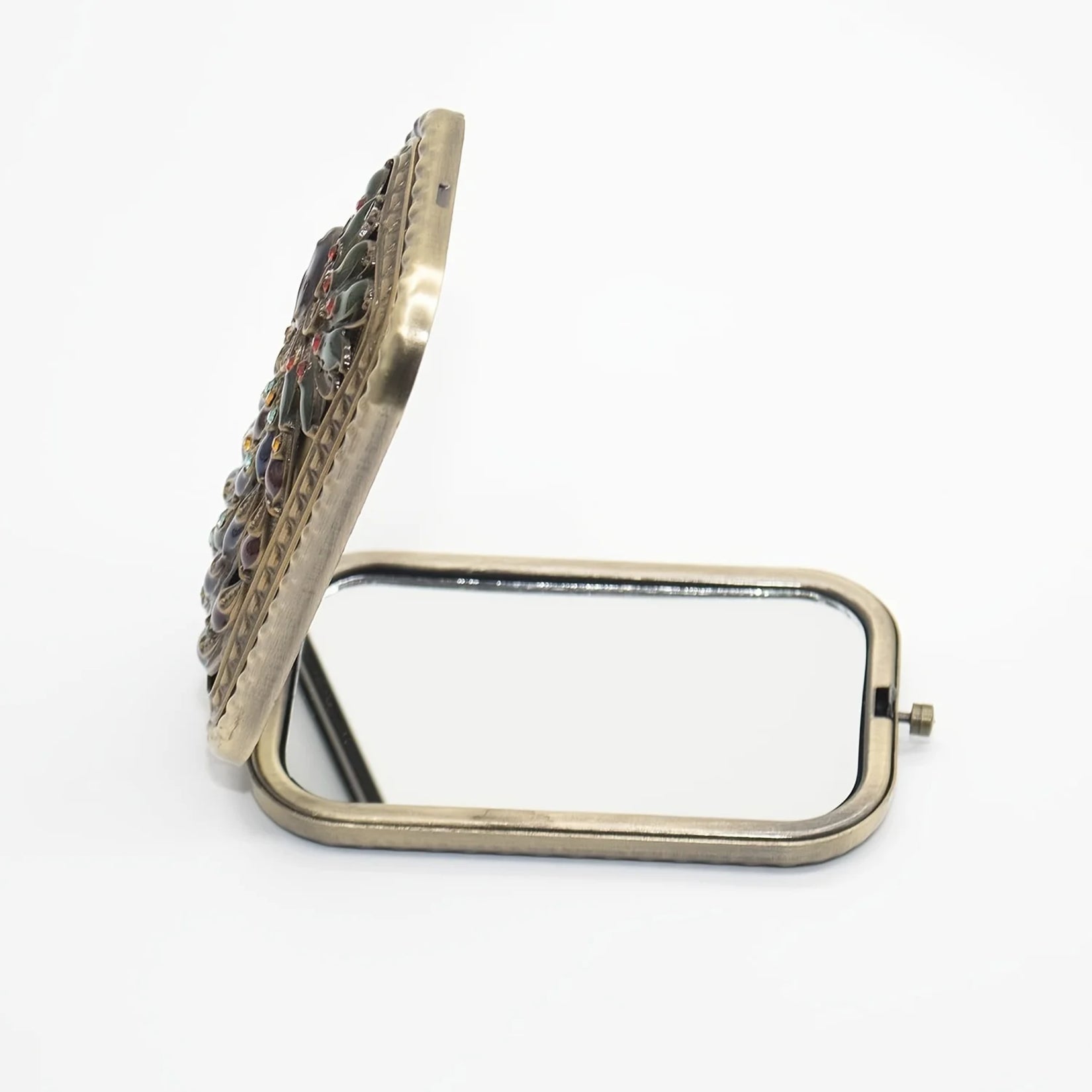 Vue latérale du miroir de poche vintage en position ouverte avec son design raffiné.