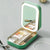Miroir de sac LED beige émettant une lumière chaude, deux coffrets ouverts sur table avec accessoires.