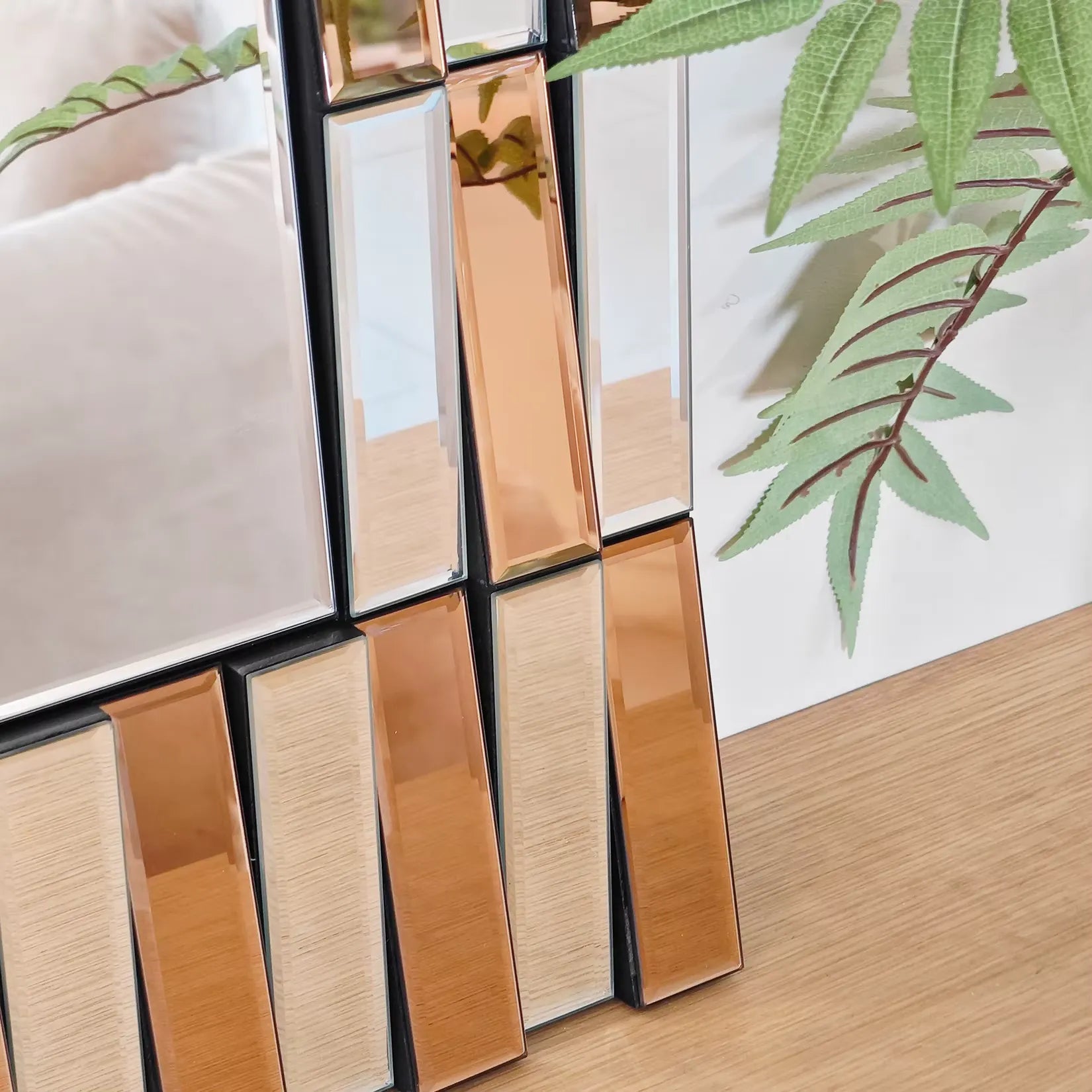 Gros plan sur le cadre doré à facettes biseautées du miroir doré design.