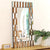 Miroir doré design accroché sur un mur en bois dans un décor naturel et chaleureux.