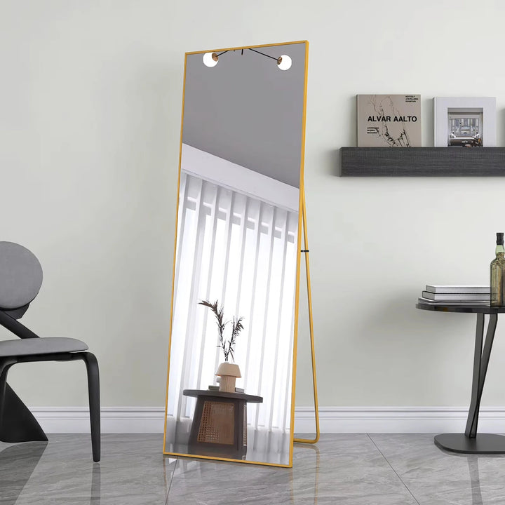Miroir doré sur pied positionné dans un coin de lecture lumineux et accueillant.