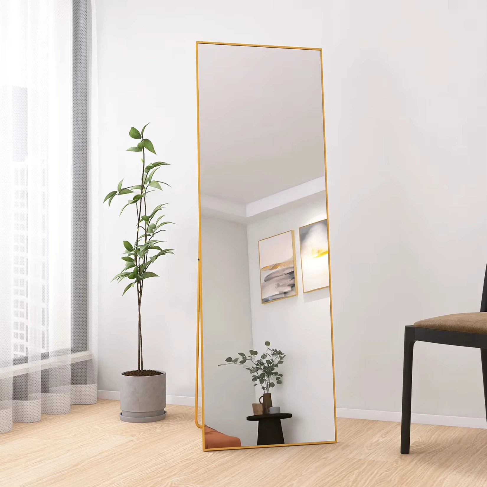 Miroir doré sur pied dans un salon contemporain, ajoutant de l'éclat à l'espace.