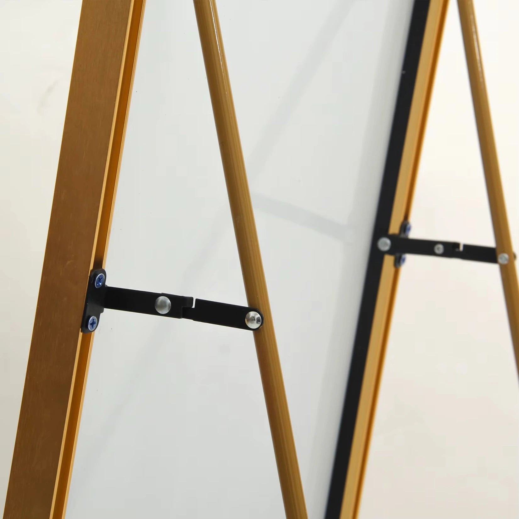 Vue rapprochée du support arrière du miroir doré sur pied, design solide et élégant.